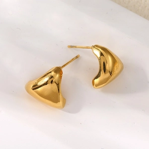 Close-up of polished gold irregular geometric triangle stud earrings on ceramic