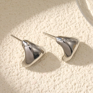 Macro shot of silver geometric triangle stud earrings with a polished mirror finish