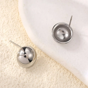 Close-up of polished silver sphere earrings with high-gloss metallic finish