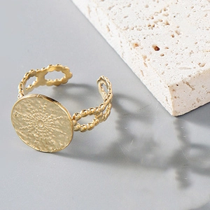 Hammered gold round medallion ring with starburst engraving and wavy open band