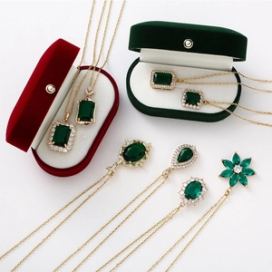 Gold crystal necklace with emerald green pendant and zircon accents on velvet gift box