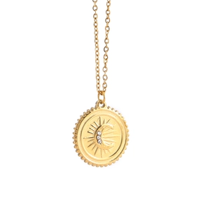 Detailed close-up of golden sun and crescent moon medallion pendant with clear crystals