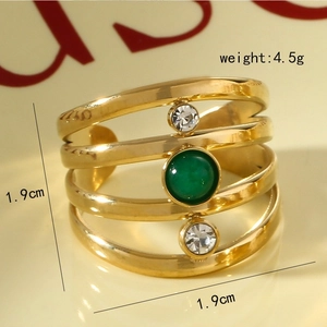 Détail de la bague multicouche dorée avec pierre verte et zircon, taille de 1,9 cm