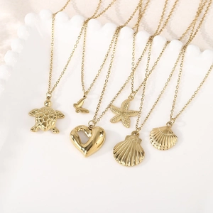 Set of six French style gold butterfly and marine pendant necklaces on white display tray