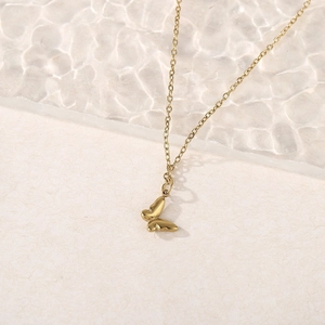 Elegant gold butterfly pendant necklace with polished finish on a stylish glass background