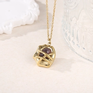 Detailed macro view of 18k gold plated titanium necklace with natural garnet stone pendant