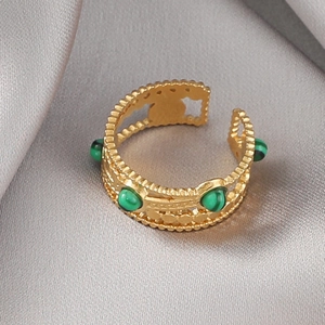 Vue détaillée de la bague vintage dorée avec quatre pierres vertes serties