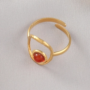 Gros plan détaillé d'une bague vintage plaquée or avec pierre rouge sur satin gris