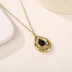 Vue détaillée du collier en titane doré avec pendentif en pierre noire en goutte