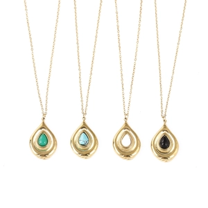 Vue macro de pendentifs goutte d'or avec malachite, turquoise et pierre noire