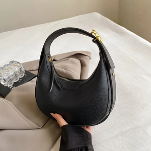Minimalist black pebble leather half-moon hobo bag with gold hardware and shoulder strap