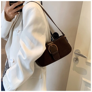 Detail of a vintage dark brown suede underarm bag with a large metallic buckle closure