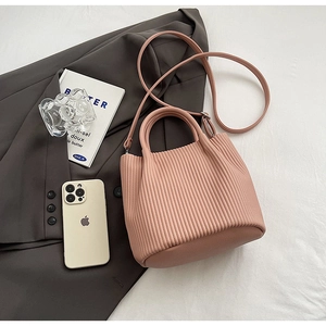 Pink pleated bucket bag showing the unique vertical texture and adjustable shoulder strap