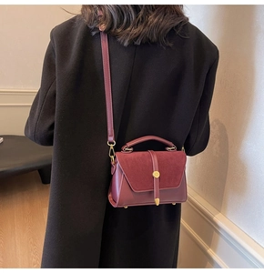 Close-up of wine red crossbody bag featuring suede patchwork and vintage metal buckle