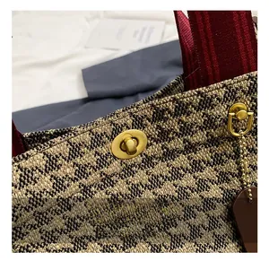 Macro shot of the premium gold metal twist lock and woven texture on this tote bag