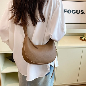 Brown half moon leather crossbody bag with adjustable strap and gold metal hardware