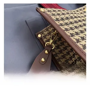 Detail of premium golden metal hook and houndstooth fabric on the shoulder bag