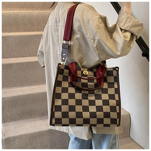 Classic checkered tote bag with leather trim shown on model for a trendy autumn look