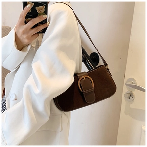 Detail showing the dark brown matte leather texture and large metal buckle of the shoulder bag