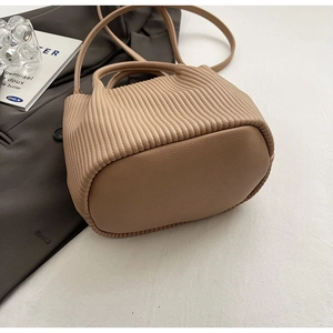 Detailed view of coffee-colored pleated bucket bag with elegant vertical texture
