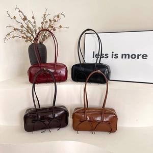 Retro underarm bowling bags in four colors with decorative bows and glossy leather finish