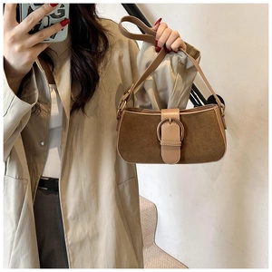Detail showing high-quality dark brown suede texture and smooth leather strap of the bag