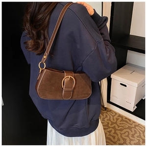 Detail of vintage brown suede shoulder bag with a large bronze metallic oval buckle