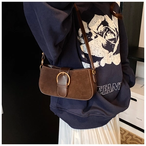 Detail of vintage brown suede baguette bag with leather trim and gold D-ring buckle