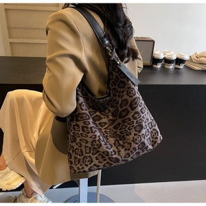 Detail view of large leopard print tote bag with adjustable black leather shoulder strap