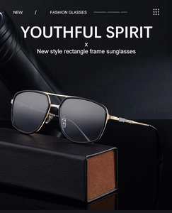 Detail of square sunglasses with gold metal temples and leather case on dark background