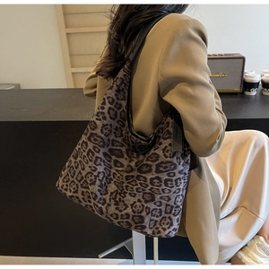 Lifestyle shot of large leopard print tote bag with black strap on woman shoulder