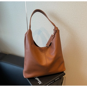 Detail of caramel lychee grain leather tote bag with elegant hanging brand tag