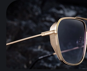 Close-up of golden vintage square frame sunglasses with detailed metal mesh side shields