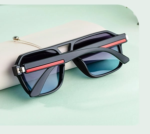 Detail of square sunglasses with double bridge, gradient lenses, and leather storage case