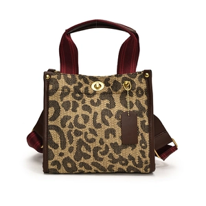 Large leopard print canvas tote bag with brown leather trim and red striped handles
