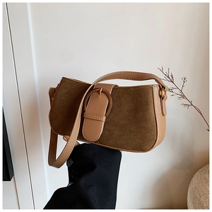 Detail of vintage patchwork leather underarm bag featuring suede panels and bronze buckle