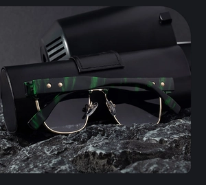Detail of square polarized sunglasses with marble pattern frame on dark rock background