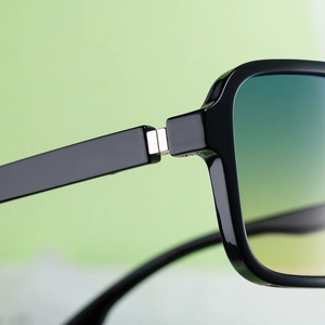 Macro shot of high-quality metal hinges and gradient lenses on black square sunglasses