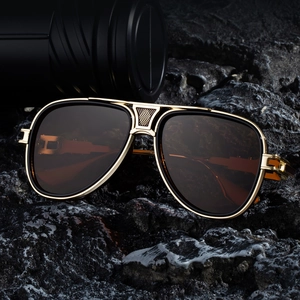 Klassische Flieger-Sonnenbrille mit goldenem Metallrahmen und dunklen Gläsern auf Stein