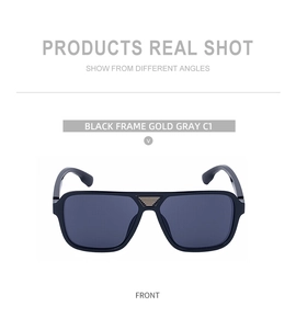 Close-up of black square sunglasses with gold horizontal metal accents on the bridge