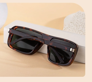 Detail of square polarized sunglasses with classic tortoise shell frame on a beige stand