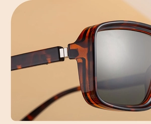 Close-up of tortoise shell frame sunglasses with high-quality metal hinge and grey lenses