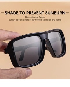 Close-up of hand holding black square polarized sunglasses with thick frames