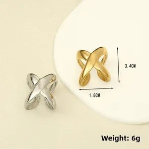 Detail view of gold and silver irregular X-shaped stainless steel rings with dimensions