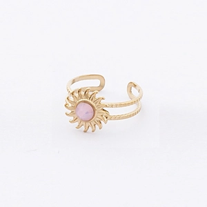 Vue détaillée d'une bague soleil dorée avec une pierre précieuse rose incrustée
