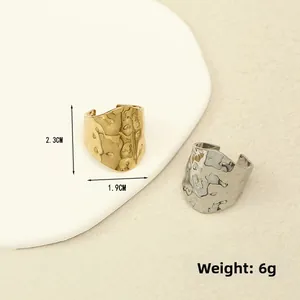 Detail view of irregular lava texture rings in gold and silver, size 2.3cm by 1.9cm