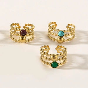 Detailed view of layered gold bead rings featuring red, turquoise, and green natural stones