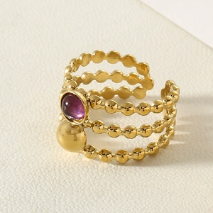 Macro detail of triple-layer titanium steel ring with purple stone and gold beads