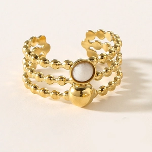 Detail view of gold multilayer beaded ring with white stone and metallic sphere accent