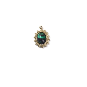 Detail of vintage oval gold pendant with sunburst texture and green malachite stone